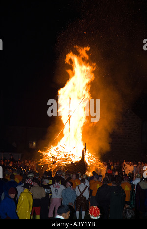 Dh Up Helly Aa fire processione LERWICK SHETLAND Guizers guardando Viking longship galley Moogi scendete al sito di masterizzazione Foto Stock