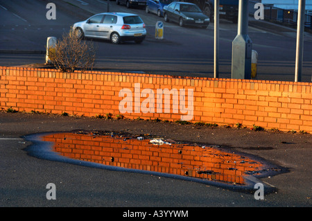 Riflessioni di parete in una pozza d'acqua. Foto Stock