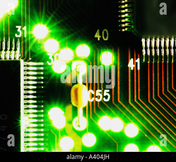 Primo piano della scheda a circuito stampato retroilluminata che mostra chip e condensatore del computer Foto Stock