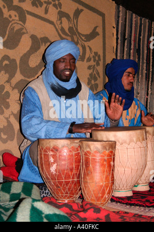 I musicisti suonano le percussioni in una tenda beduina, Merzouga Erg Chebbi, Marocco, Africa nord-occidentale Foto Stock