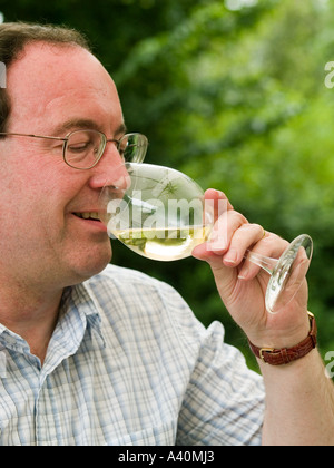 Vino bianco di essere apprezzato da un maschio baby boomer a un pranzo alfresco Foto Stock