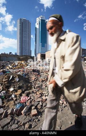 Uighur uomo a camminare attraverso il sito di costruzione Foto Stock