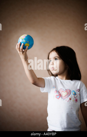 Bambina detiene il mondo a portata di mano Foto Stock