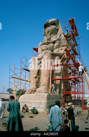 Uno dei i Colossi di Memnon sulla sponda ovest del Nilo a Luxor Egitto in fase di conservazione e reperti archeologici investigatio Foto Stock