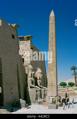 Il magnifico tempio di Luxor con colossali statue di Ramses II e un obelisco di fronte all'ingresso tralicci Foto Stock