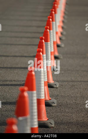 Rosso su strada traffico coni allineati lungo il lato di una strada. Foto Stock