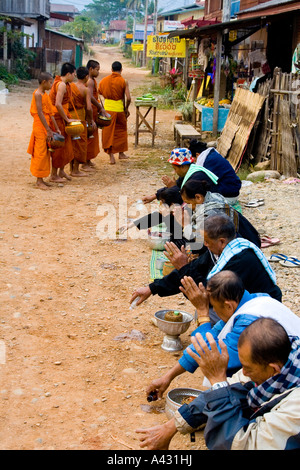 La popolazione locale pregare dopo aver Alms Vang Vieng Laos Foto Stock