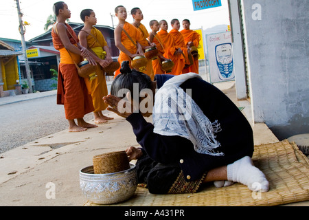 Donna locale prega dopo aver Alms Vang Vieng Laos Foto Stock
