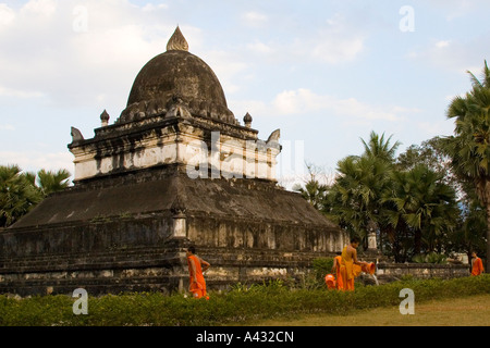 Il debuttante irrigazione monaci presso Lotus o anguria Stupa Wat Visoun Wisunarat Luang Prabang Laos Foto Stock