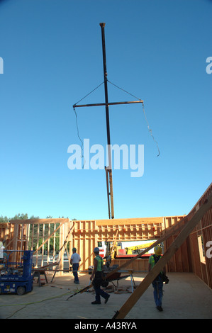 Costruzione - Vista della gru senza un carico in cantiere con operai in primo piano Foto Stock