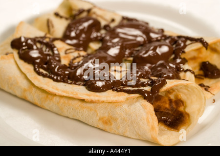 Due frittelle ripiegato su di un piatto di portata con il cioccolato fuso Foto Stock