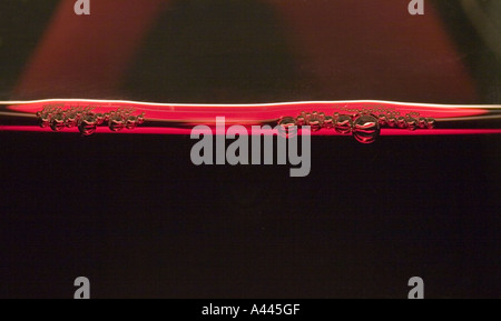 Close up dettaglio di bolle in un bicchiere di vino rosso Foto Stock