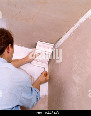 Close-up di uomo sostituisce Gesso cornice a soffitto Foto Stock
