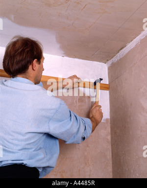 Close-up di uomo sostituisce Gesso cornice a soffitto Foto Stock