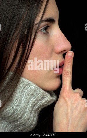Giovane donna dei nottolini di tenuta a labbri close up vista laterale Foto Stock