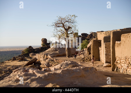 Case del Borgo di Sanga appollaiato sulla scarpata superiore e in esecuzione i bambini ,Paese Dogon del Mali, Africa occidentale Foto Stock