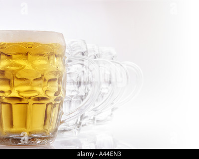Lineup di British pub tazze, uno riempito con la birra. Foto Stock