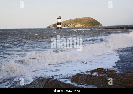 Punto PENMON Isola di Anglesey North Wales UK Dicembre cercando lungo la spiaggia sassosa verso Penmon Faro e Puffin isola in inverni tempestoso giorno Foto Stock