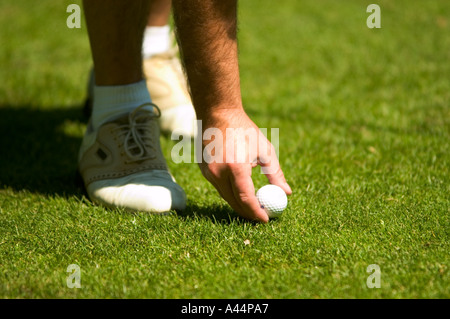 Giocatore di golf tees fino una pallina da golf Foto Stock