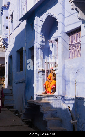 India Rajasthan Bundi colorfully vestito donna sat nel blu dipinto di casa porta Foto Stock