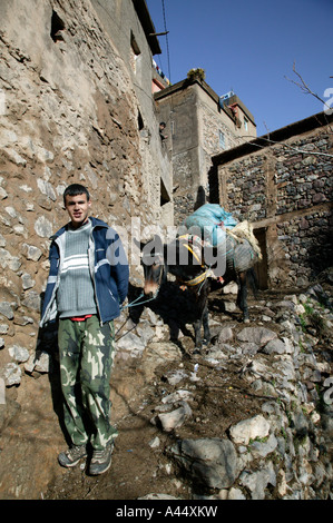 Ragazzo asino conduce attraverso il tradizionale villaggio berbero, Alto Atlante, Toubkal Parco Nazionale di Marocco, Africa del Nord, 2007 Foto Stock