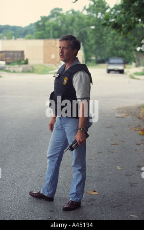 Plainclothes sergente di polizia con tenuta in mano radio. Kansas City, MO, il dipartimento di polizia pista Squad. Foto Stock