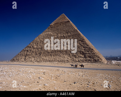 Egitto Nord Africa Medio Oriente Area del Cairo Giza piramide di Khufu con turisti di passaggio sulla strada di cavallo e carrozza Foto Stock