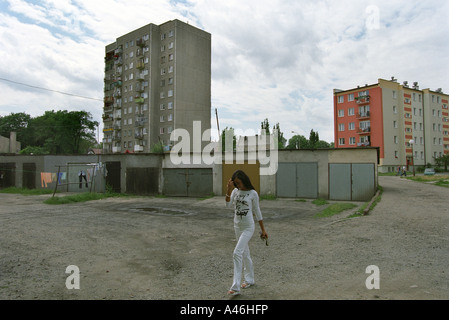 Giovane donna a piedi attraverso un cortile di una zona residenziale a Slubice, Polonia Foto Stock