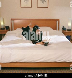 La donna la lettura sul letto Foto Stock