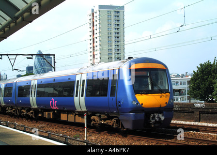 Linea principale binari e ultima carrozza del treno passeggeri C2C in direzione del terminal della City of London a Fenchurch Street & Gherkin Building Inghilterra UK Foto Stock