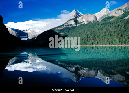 Canadian Rockies refelected ancora nelle calme acque del Lago Louise, Snow capped e alberata montagne riflessioni Foto Stock