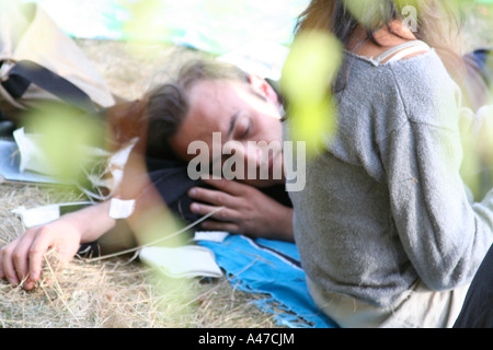 Uomo dorme accanto a donna sotto l albero in Chorlton Water Park, Manchester, Inghilterra Foto Stock