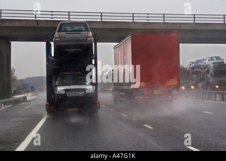 Cattive condizioni di guida in presenza di neve e di tempo umido visibile attraverso il parabrezza auto su autostrada britannica, England, Regno Unito Foto Stock