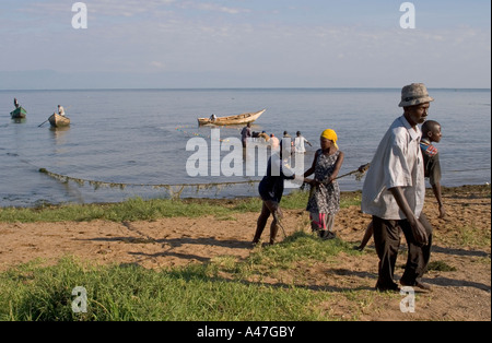 I pescatori e gli abitanti di un villaggio, alaggio in reti sulla riva del lago Albert, Uganda settentrionale, Africa orientale Foto Stock