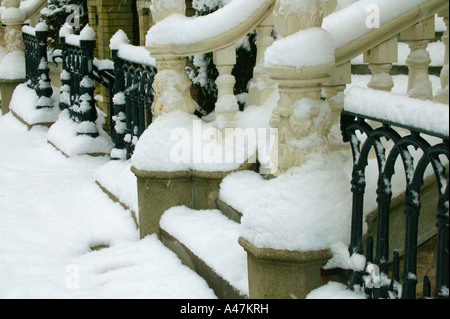 Coperta di neve passi e ferro battuto recinzione Foto Stock