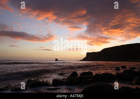 Vista verso il nero al NAB Saltwick Bay nei pressi di Whitby nel Nord Yorkshire coast mostra nuvole turbolento arancione brillante Foto Stock