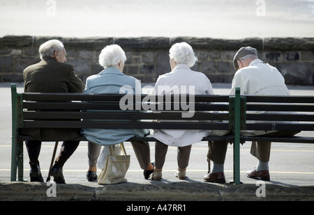 Gli anziani seduti su una panchina di fronte al mare a Weston Super Mare nel Somerset REGNO UNITO Foto Stock