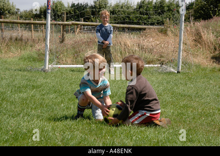 Tre giovani ragazzi che giocano a calcio Pembrokeshire Wales UK Europa Foto Stock