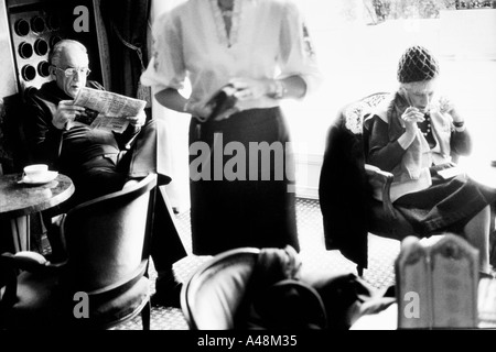 L'uomo leggendo un giornale in sole di primavera nel coffee shop nel famoso Gellert Hotel e Spa , Budapest Foto Stock