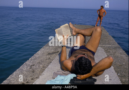 Un vacanziere lettura e a prendere il sole sul lungomare di Yalta. Crimea Ucraina Foto Stock