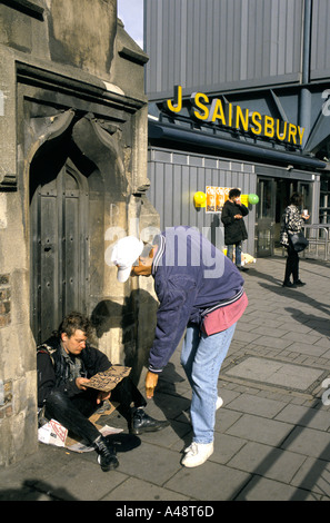 Dare i soldi per i senzatetto a mendicare fuori Sainsbury's supermercato camden town london Foto Stock