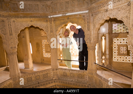 India Rajasthan Jaisalmer Amar Sagar del XIX secolo in pietra arenaria scolpita tempio Jain i turisti occidentali guardando interno Foto Stock