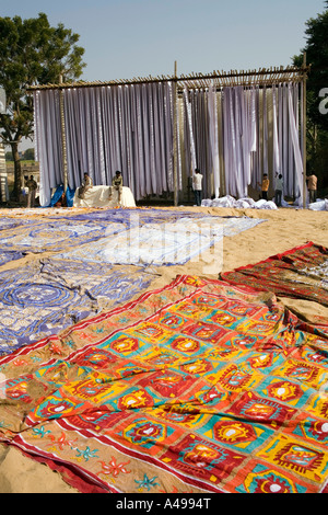 India Rajasthan Sanganer artigianato tessile tessuto di essiccazione al sole su alte scaffalature e sulla sabbia Foto Stock