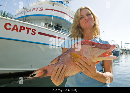 USA Florida Keys, Key West donna felice pescatore mantenendo la pesca del giorno. Isola di stock Foto Stock