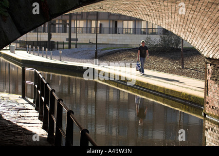 Uomo che cammina lungo il percorso del canale, Tariffa Street Bridge, vantaggio Quay, Bacino di Piccadilly, Manchester, Regno Unito Foto Stock