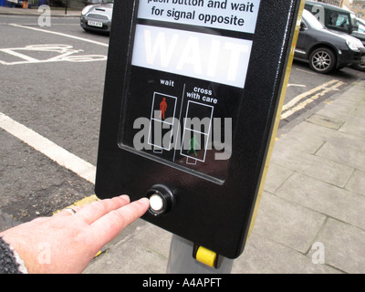 Premendo il pulsante in un pellicano attraversamento pedonale, UK. Foto Stock