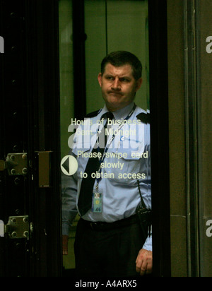Un scontenti guardia di sicurezza sul dovere con scheda di sicurezza accesso solo Foto Stock