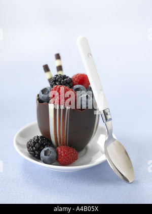 Mousse di cioccolata in tazza guarnita con frutti di bosco freschi Foto Stock