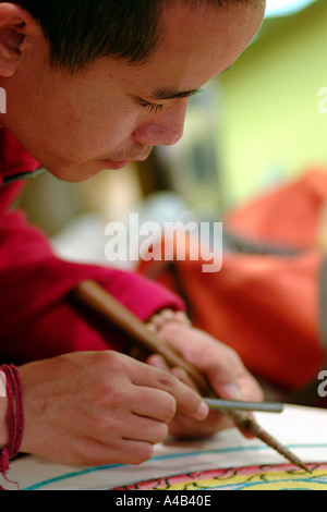 Monaco tibetano lavorando su un mandala Foto Stock