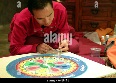 Monaco tibetano lavorando su un mandala di sabbia Foto Stock